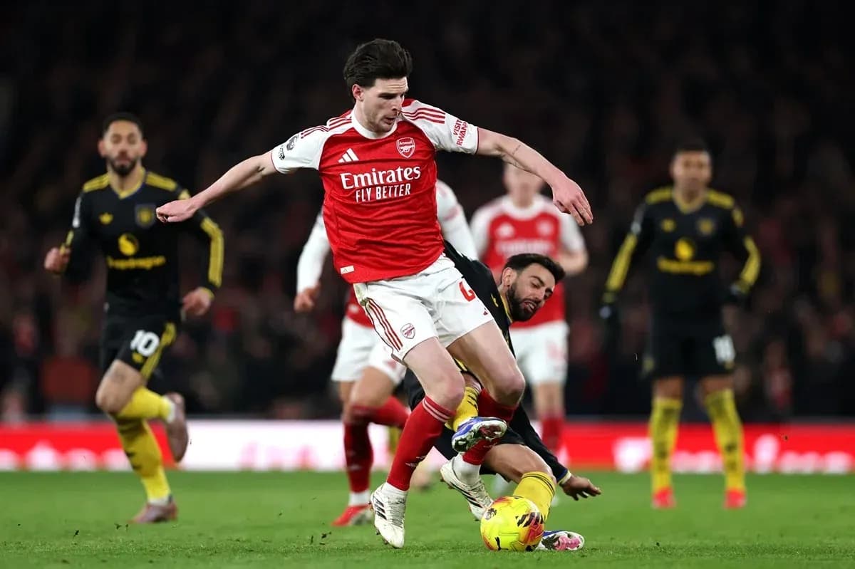 Arsenal player being tackled during a match