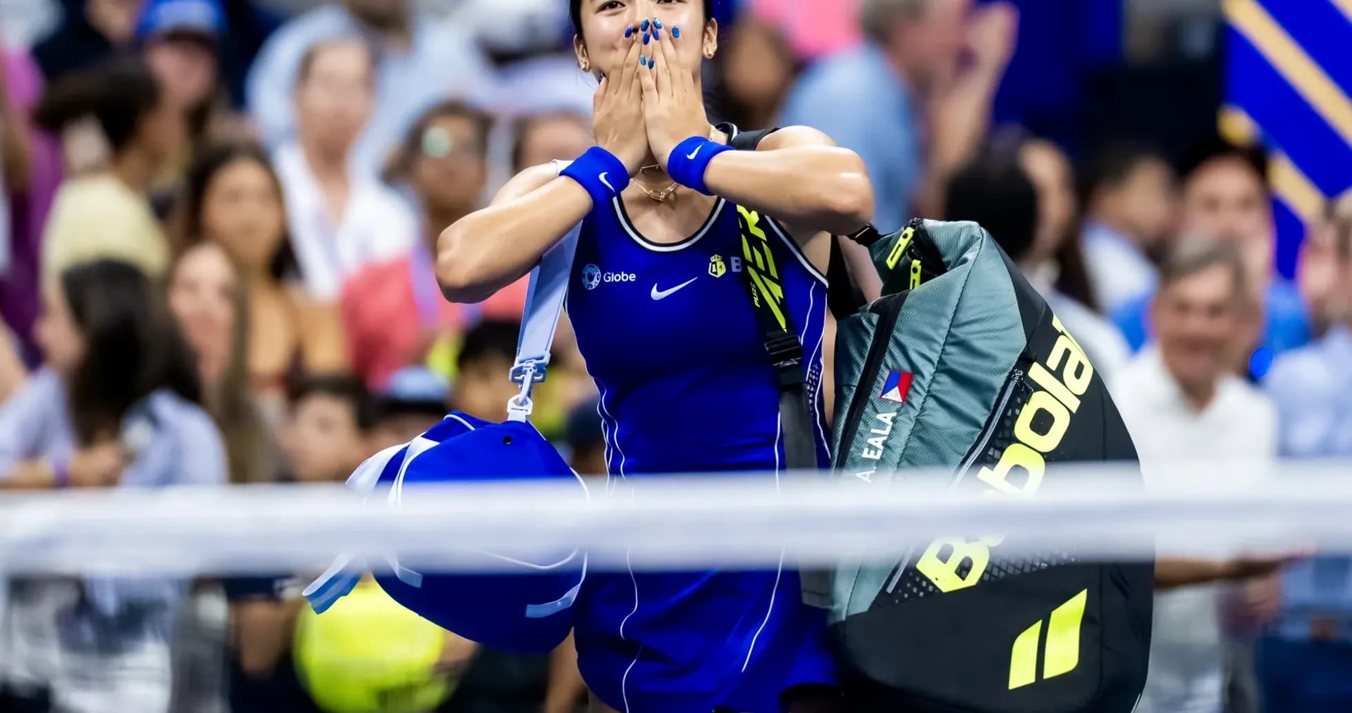 Tennis player celebrating with bags after match