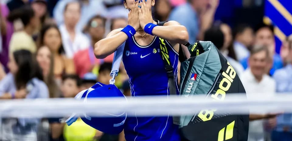 Tennis player celebrating with bags after match