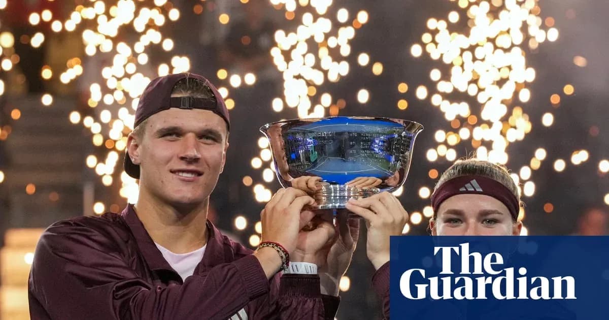 Two players celebrating with trophy and fireworks