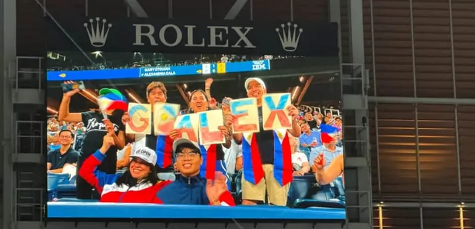 Fans cheering with signs in stadium stands