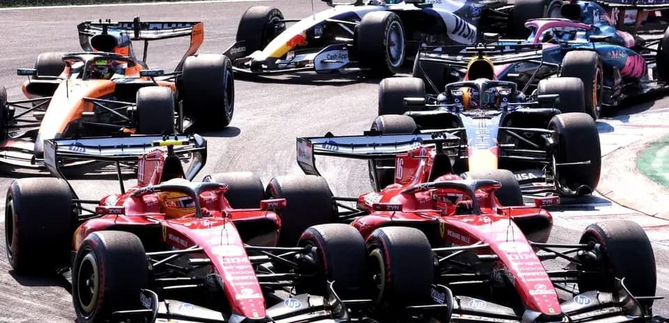 Several Formula 1 cars racing closely on track