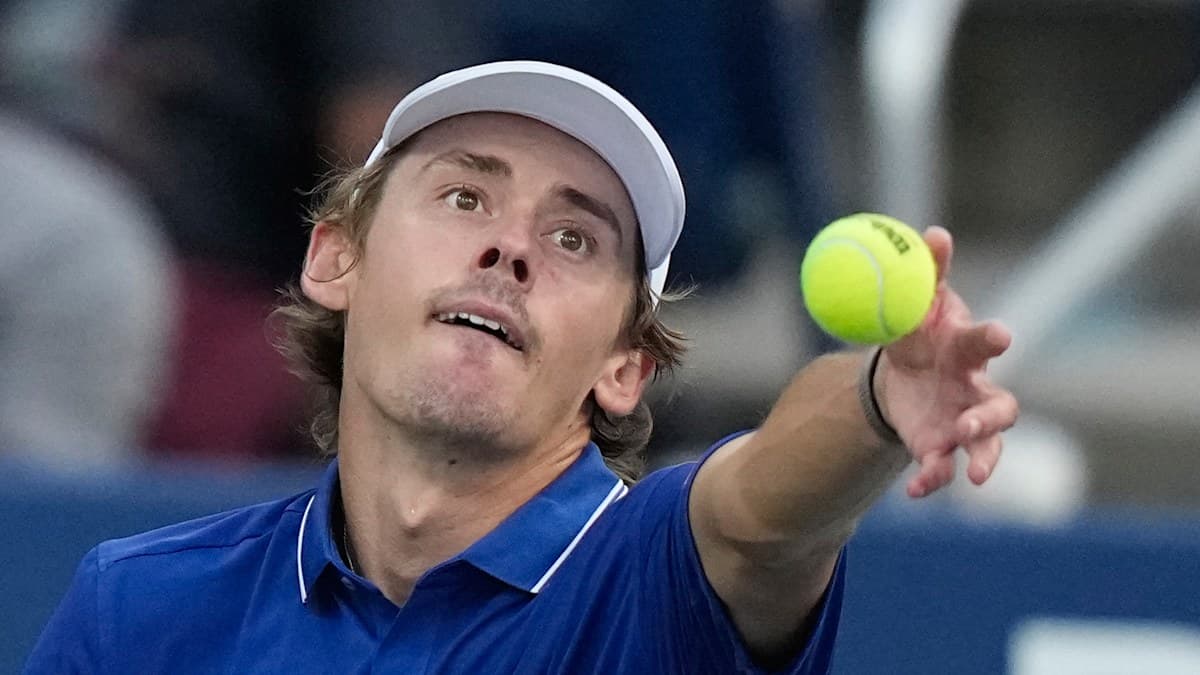 Player serving tennis ball during match