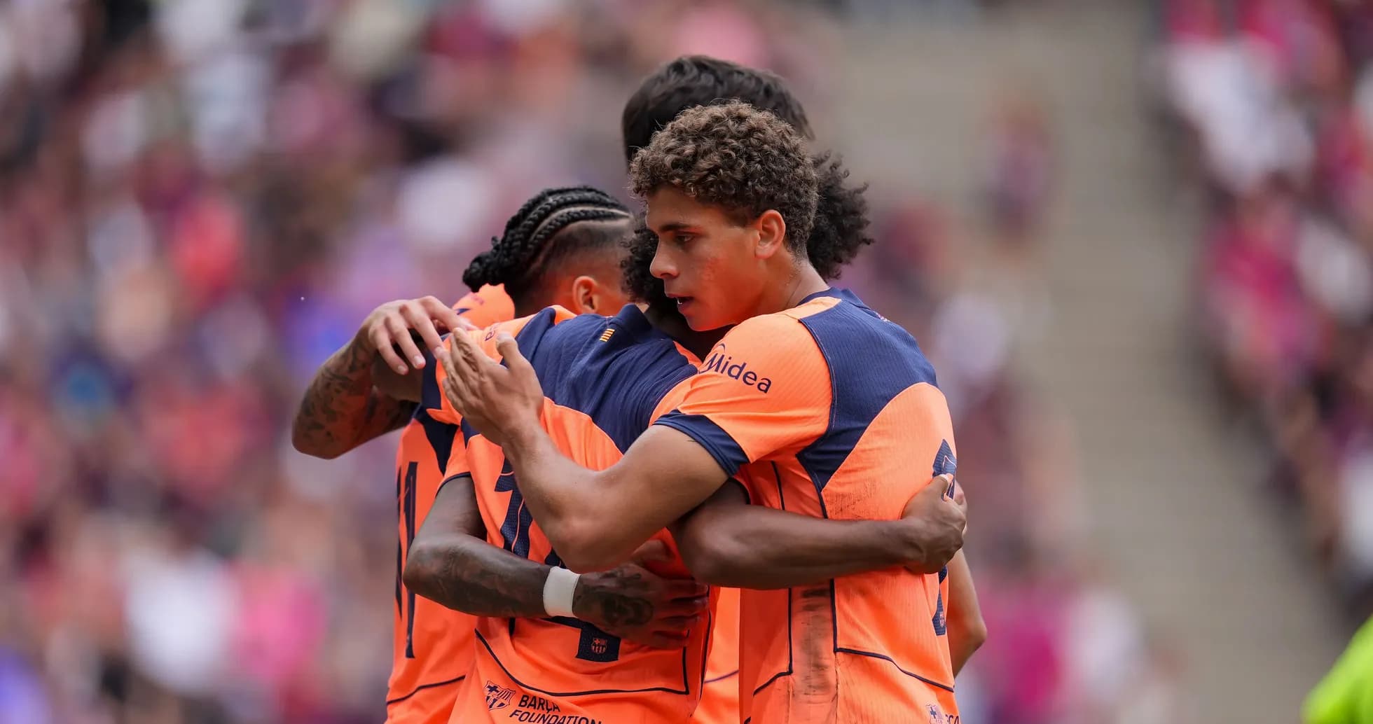 Players celebrating a goal in orange jerseys
