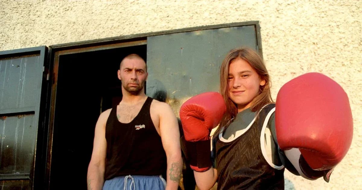 Young girl in boxing gloves with trainer outside gym