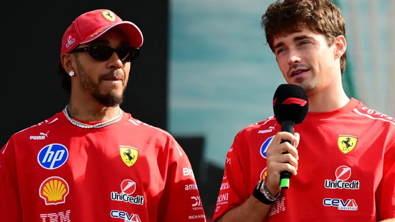 Two drivers in Ferrari shirts speaking at event