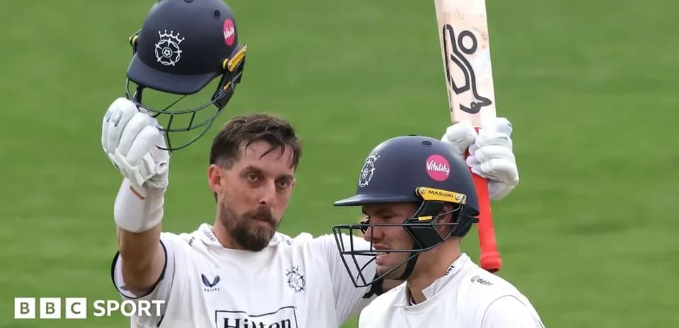 Cricketer celebrating with helmet raised after scoring