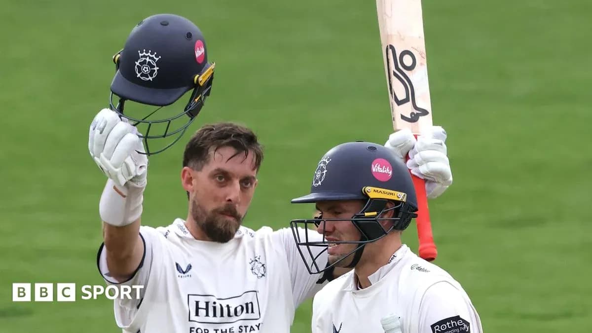 Cricketer celebrating with helmet raised after scoring