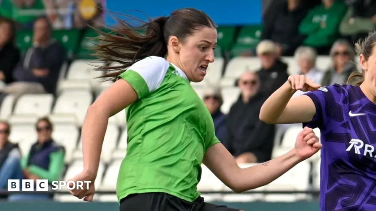 Player in green jersey dribbling past opponent