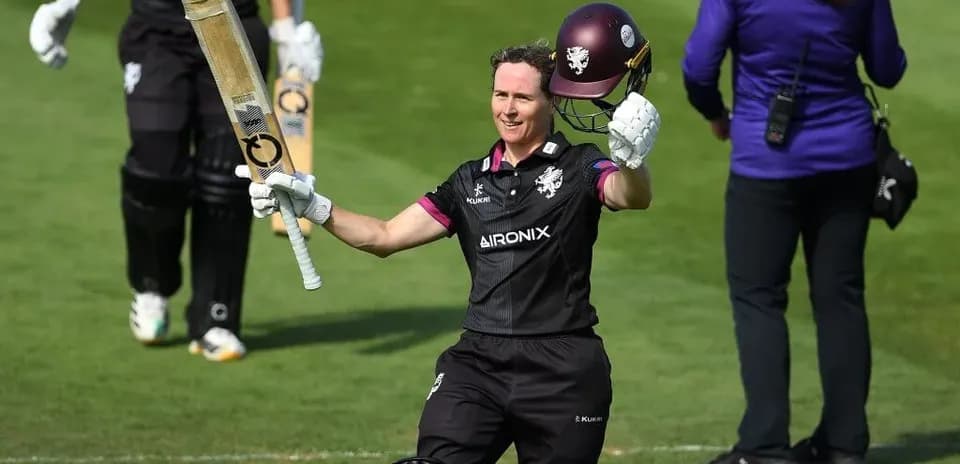 Cricketer celebrating century with bat raised