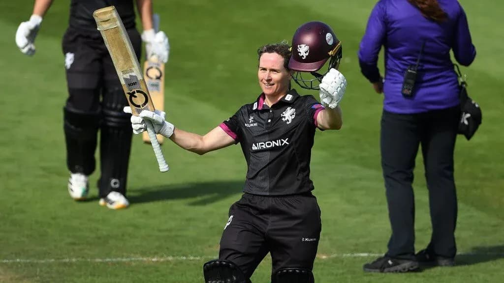Cricketer celebrating century with bat raised