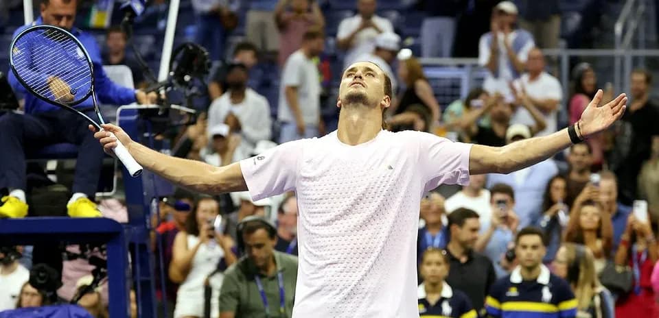 Player celebrating victory with arms raised on court