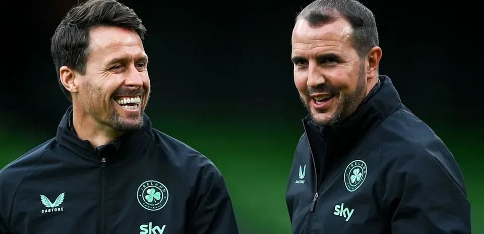 Two coaches smiling and talking during training session