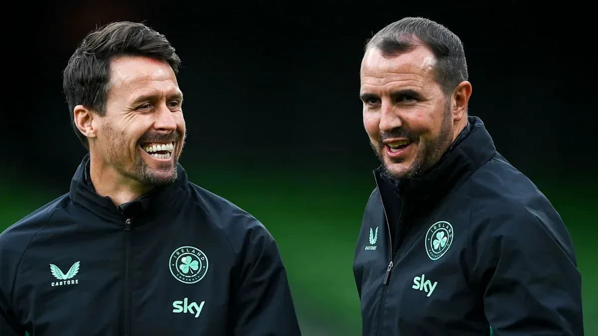 Two coaches smiling and talking during training session
