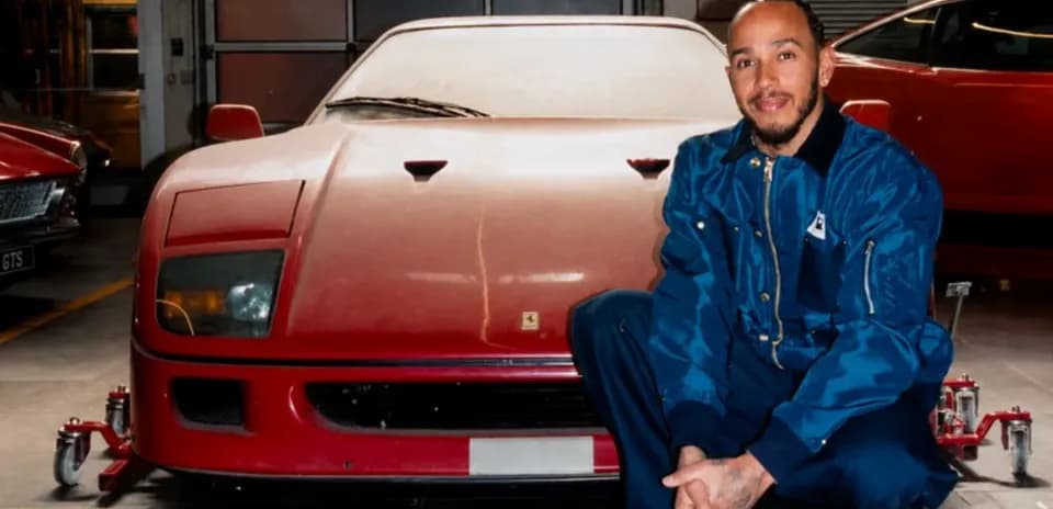 Person kneeling beside a red vintage sports car