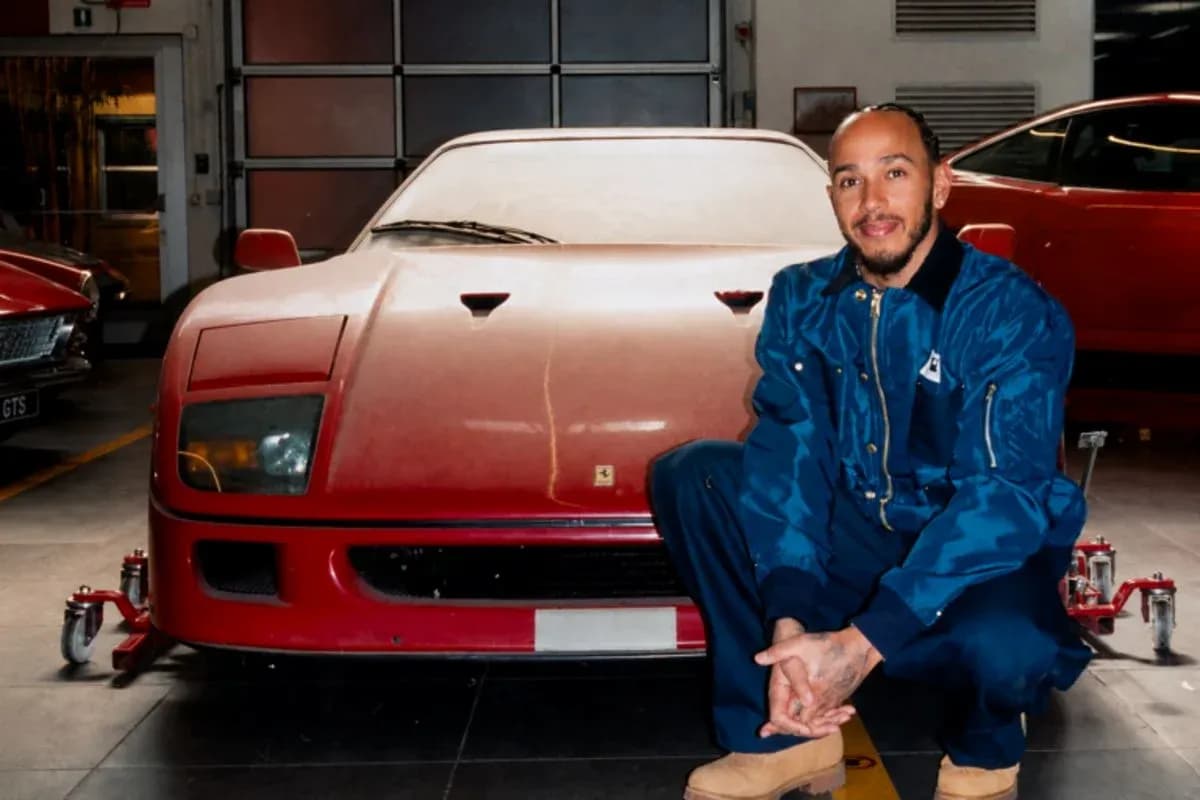 Person kneeling beside a red vintage sports car