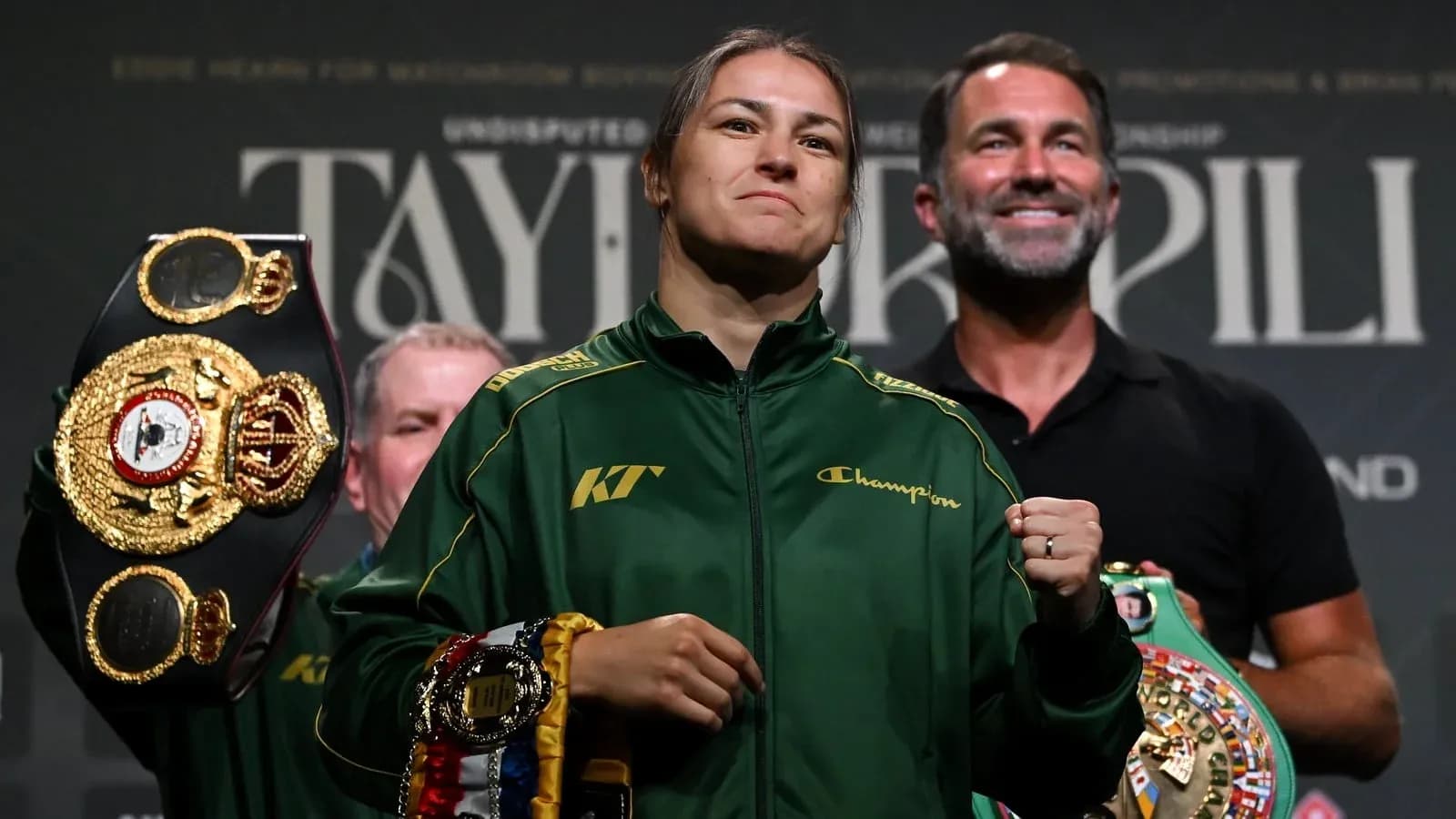 Female boxer holding championship belts at press event Female boxer holding championship belts at press event
