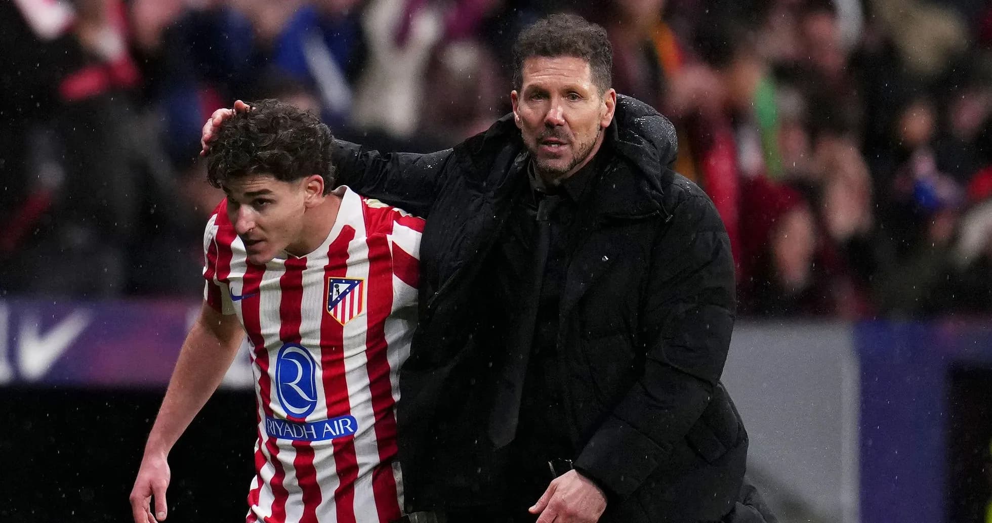Player receiving guidance from coach on the pitch