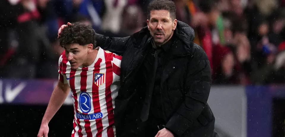 Player receiving guidance from coach on the pitch