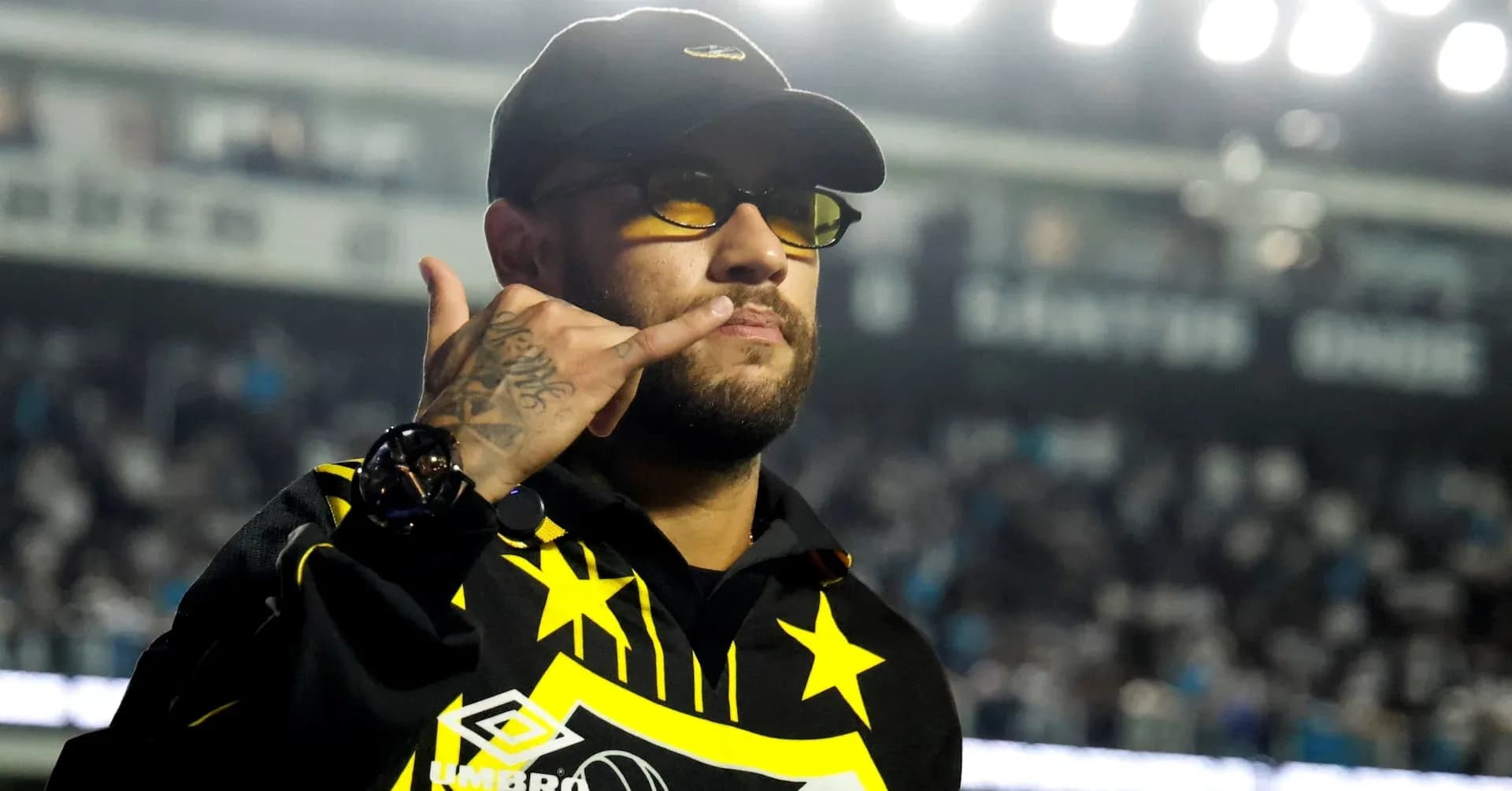 Man in sunglasses making a gesture at stadium