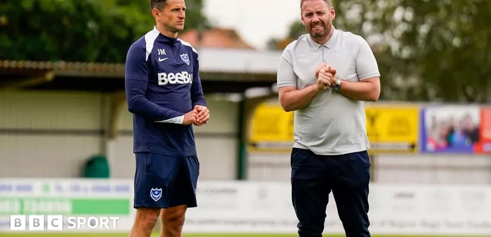 Two coaches discussing on training pitch