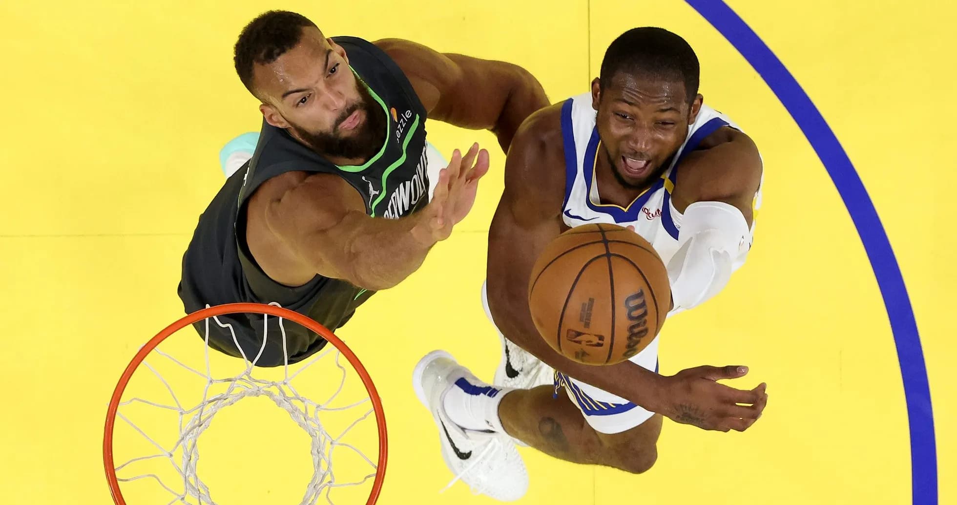 Player attempting a layup while defended under the basket