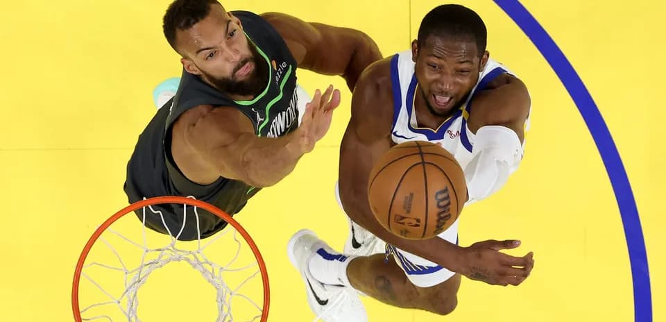Player attempting a layup while defended under the basket