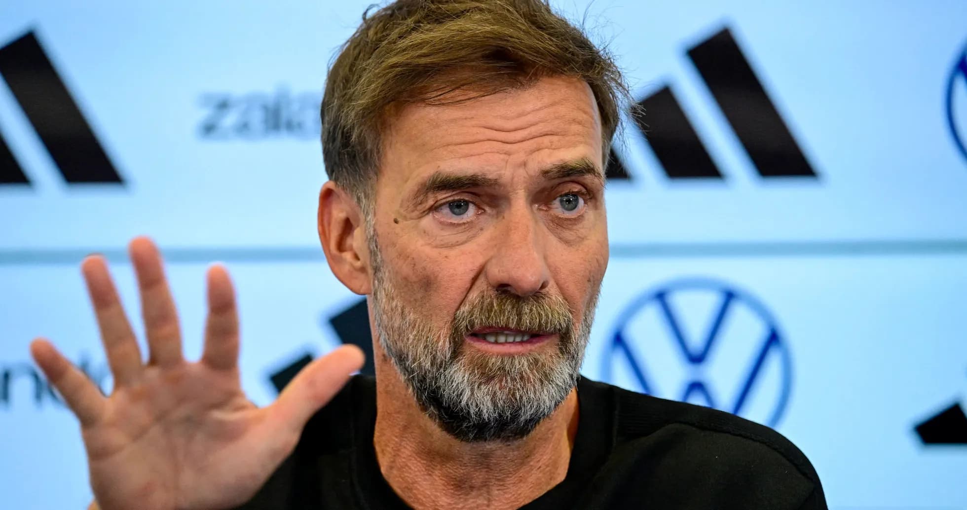 Manager speaking at press conference with raised hand