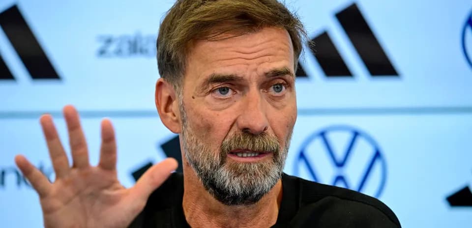 Manager speaking at press conference with raised hand