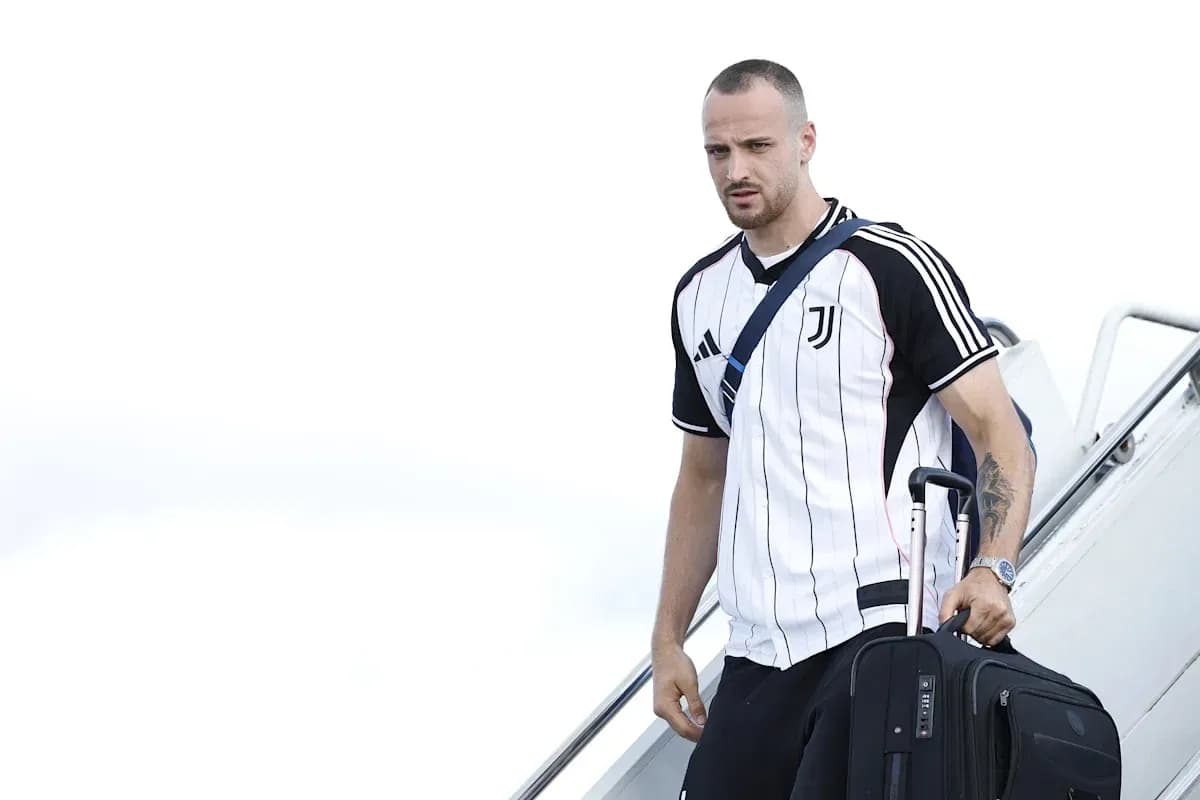 Player arriving with suitcase wearing Juventus jersey