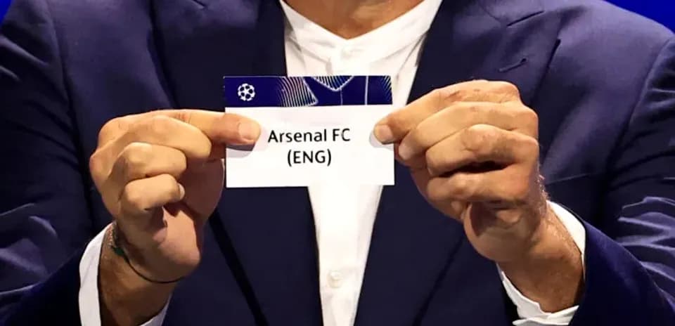 Official holds Arsenal FC draw card during event