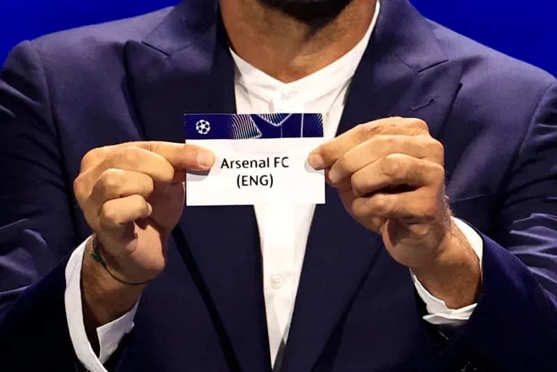 Official holds Arsenal FC draw card during event