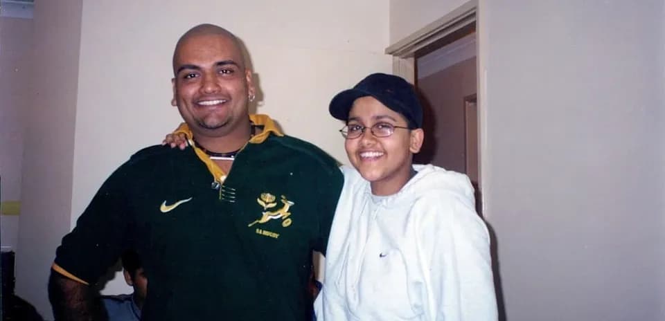 Two people posing together indoors, smiling