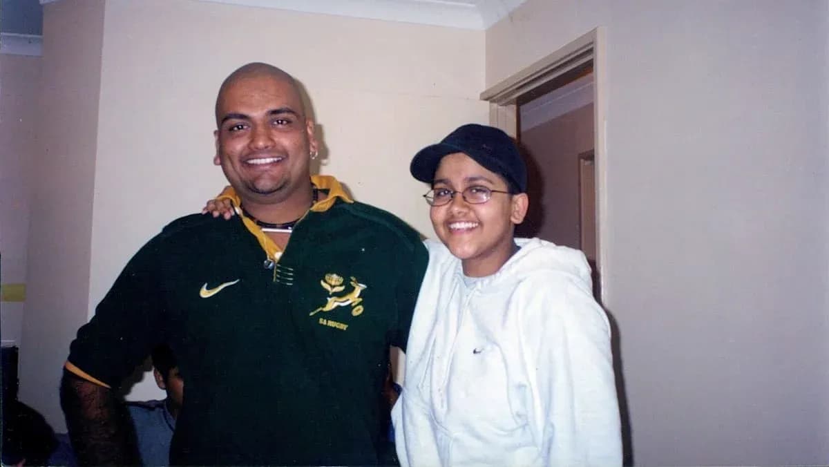 Two people posing together indoors, smiling