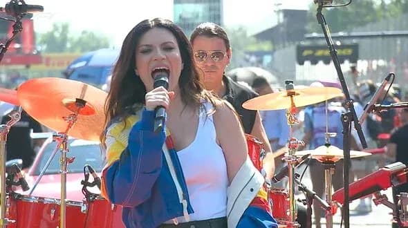 Singer performing on stage with band at event