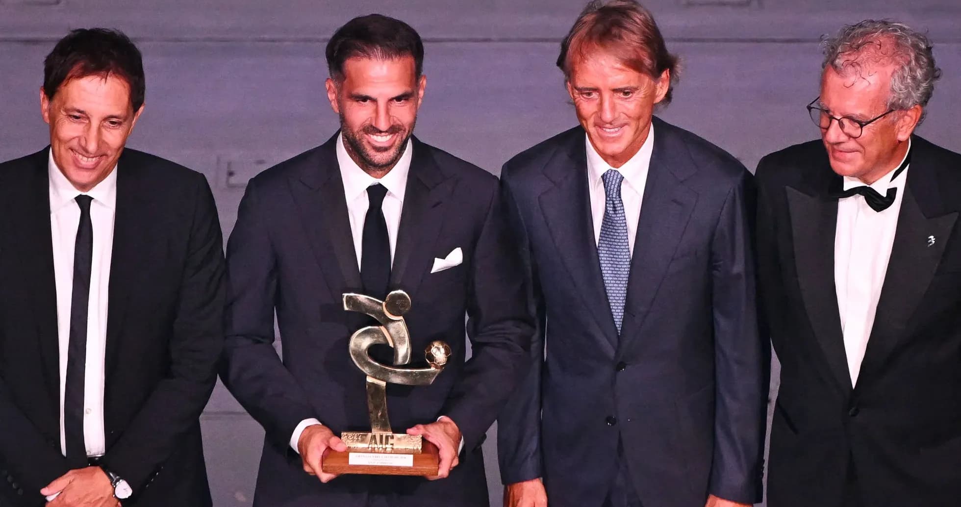 Four men posing with an award at ceremony