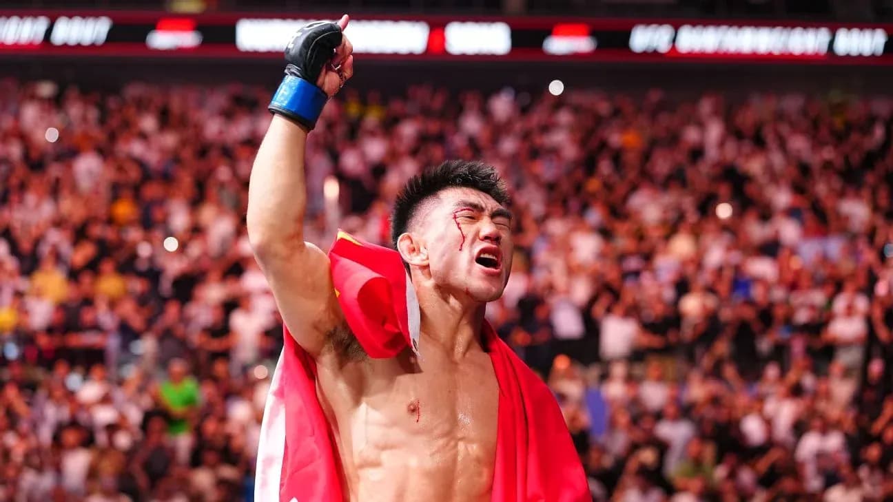 Fighter celebrating victory with raised hand and flag