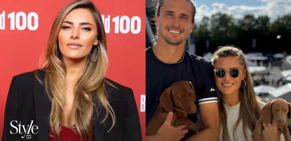 Two people posing with puppies at outdoor event