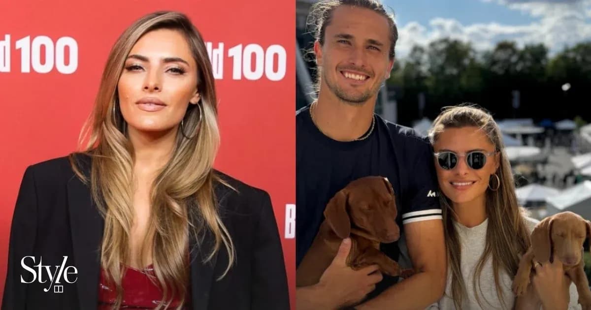 Two people posing with puppies at outdoor event