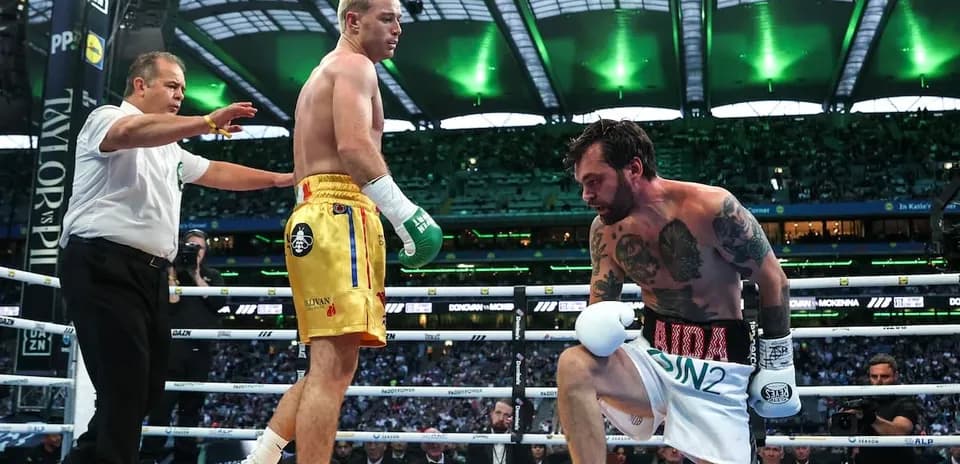 Boxers in ring with referee during match action