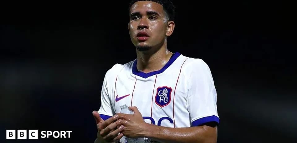 Player in white jersey holding water bottle
