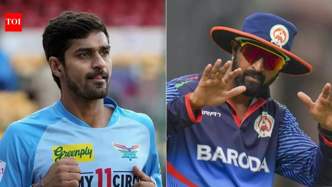 Two cricketers in team uniforms on field