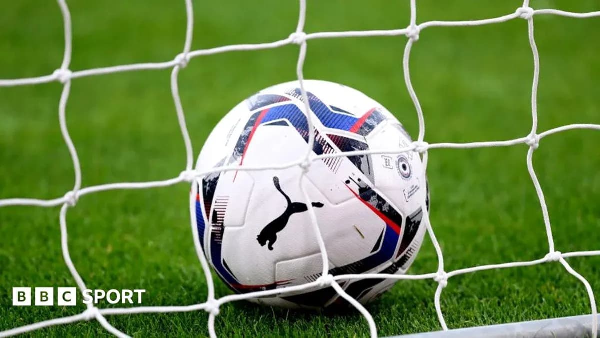 Soccer ball in goal net on grass field
