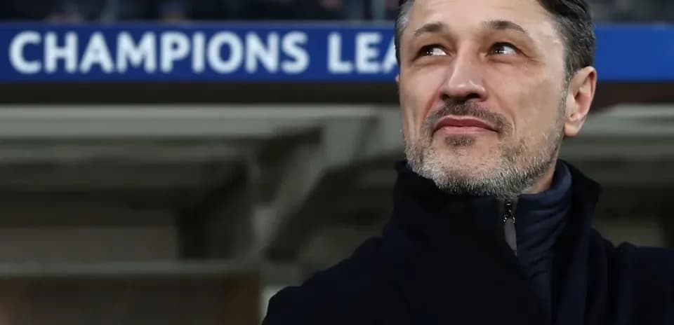 Coach observing match with Champions League signage behind