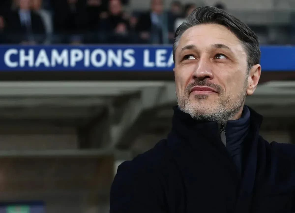 Coach observing match with Champions League signage behind