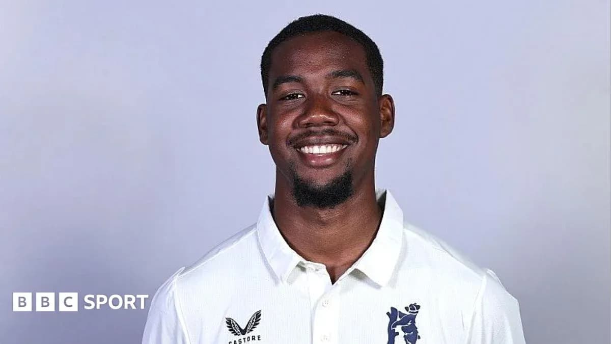 Smiling cricket player in white team jersey