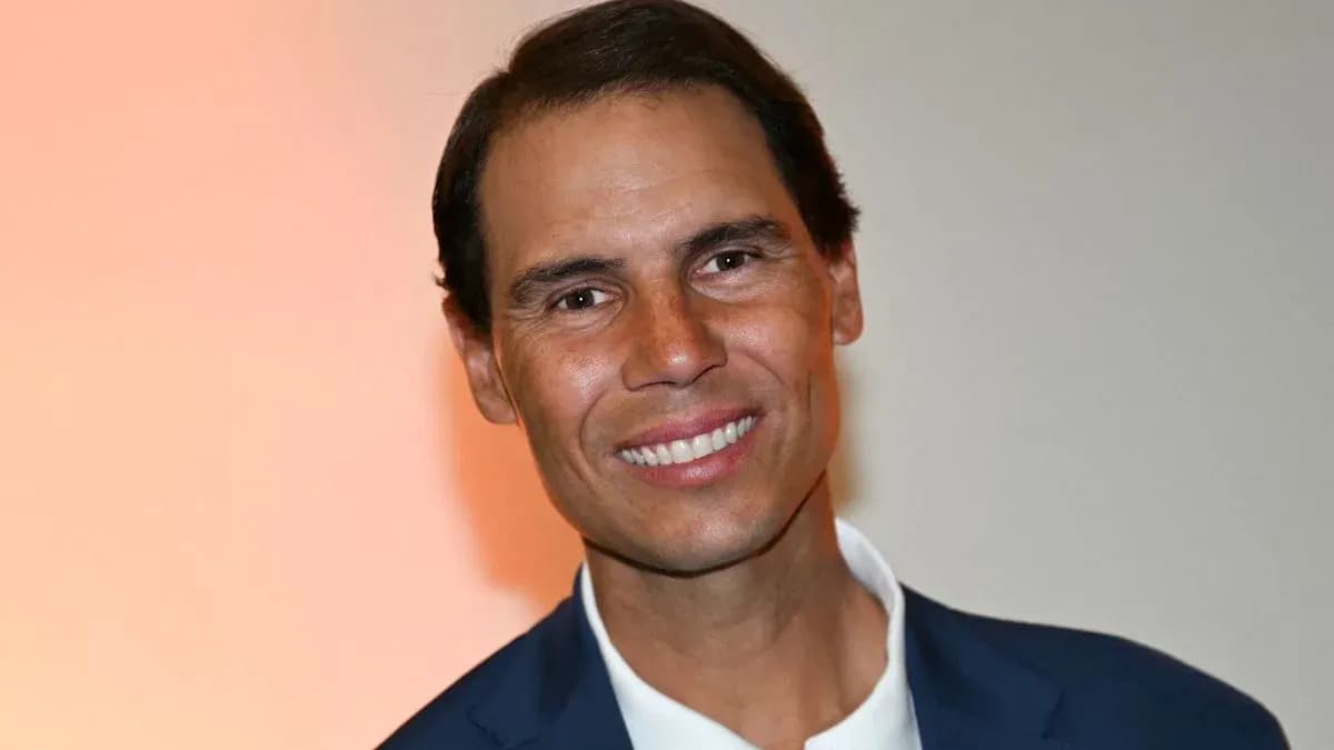 Man in suit smiling at event backdrop