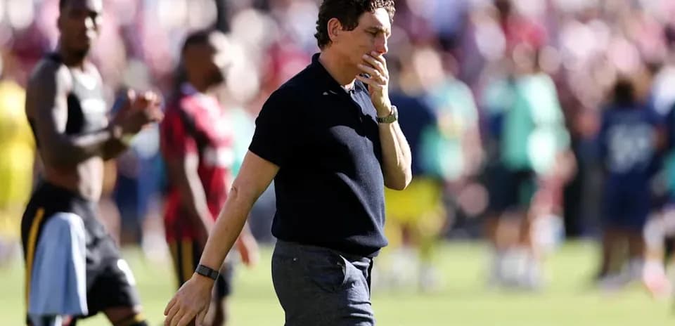 Coach walking on the pitch after the match