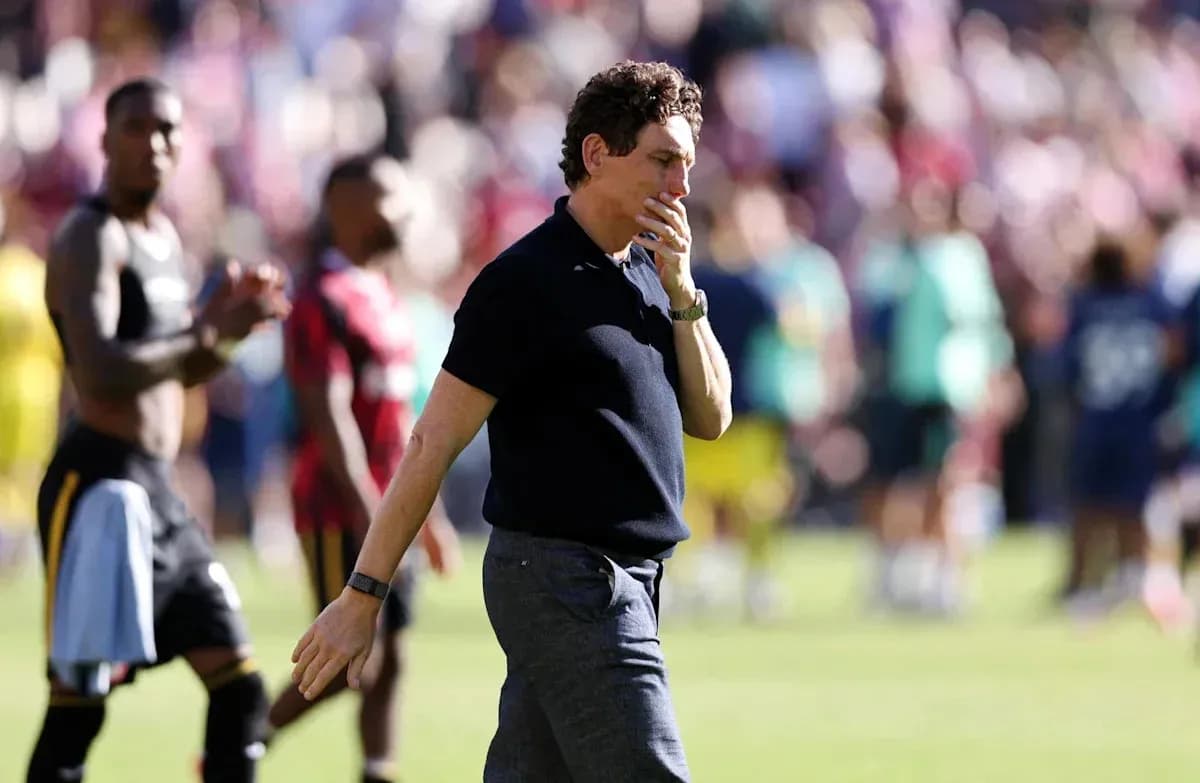 Coach walking on the pitch after the match