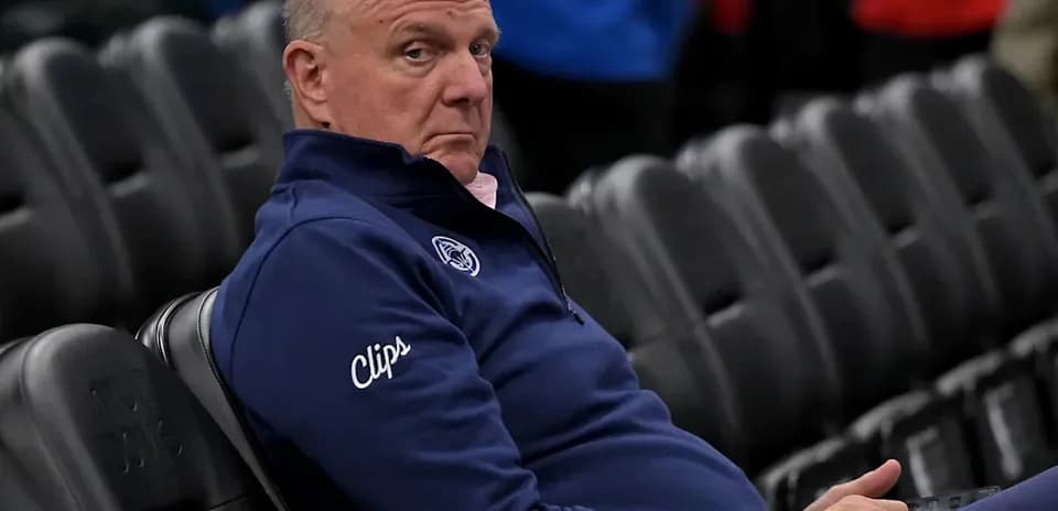 Person seated in arena wearing Clippers jacket